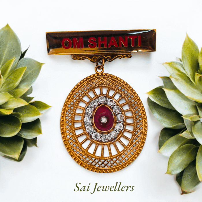 IMG_20250817_174546 Golden OM SHANTI badge with circular designer locket featuring red stone and diamond-like accents, displayed with green succulents – Sai Jewellers.